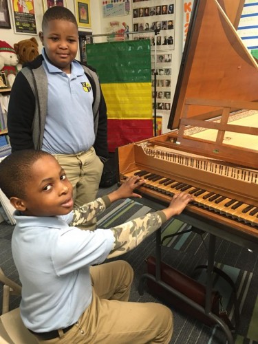 Two young students get up-close with the harpsichord.