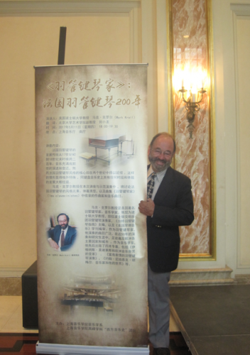 Mark Kroll stands before a poster for his recital in Shanghai. 