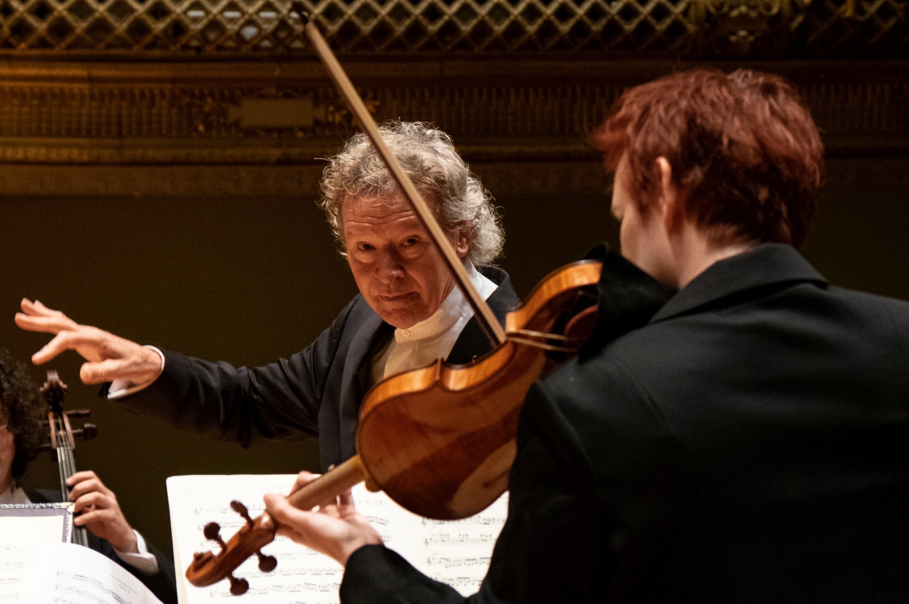 Harry Christophers conducting with a violinist in the foreground